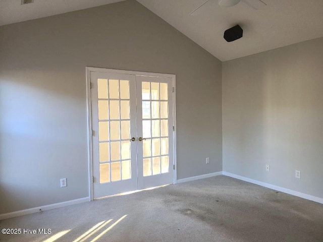 carpeted empty room featuring french doors and vaulted ceiling