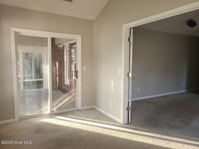 empty room featuring light colored carpet and lofted ceiling