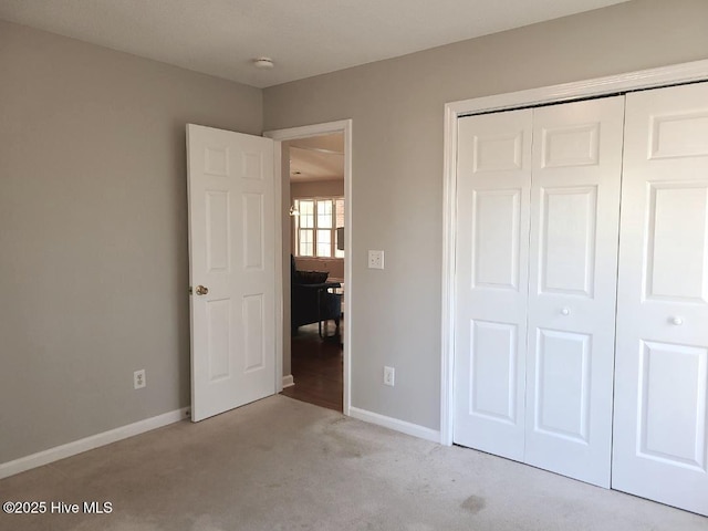 unfurnished bedroom with light carpet and a closet