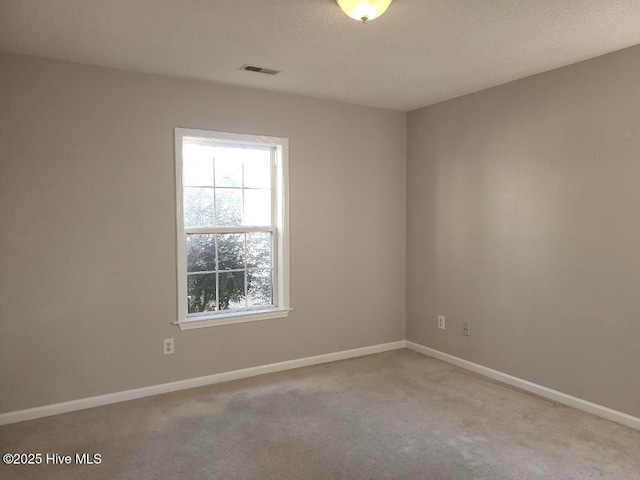 carpeted spare room featuring a textured ceiling