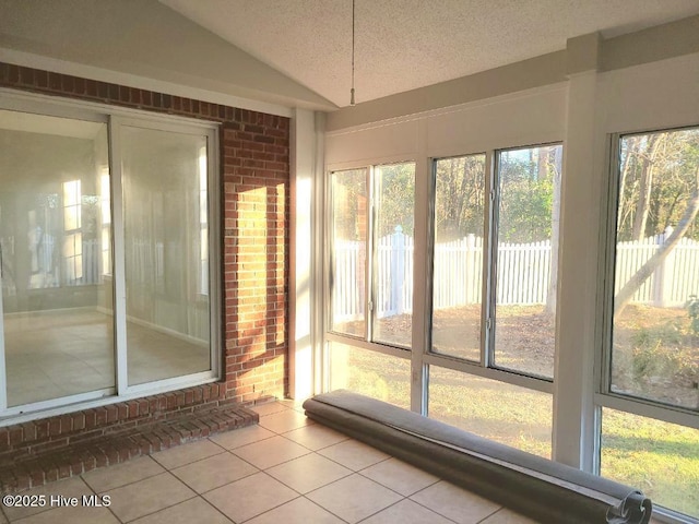 unfurnished sunroom featuring vaulted ceiling