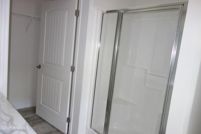 bathroom with hardwood / wood-style flooring and walk in shower