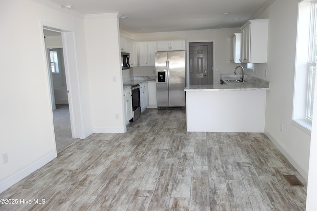 kitchen with sink, white cabinetry, stainless steel appliances, and light wood-type flooring