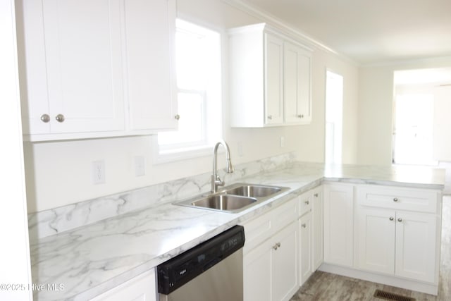 kitchen with white cabinetry, stainless steel dishwasher, ornamental molding, and sink