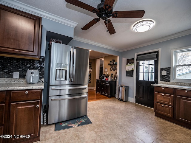 kitchen featuring stainless steel fridge, dark brown cabinetry, and ornamental molding