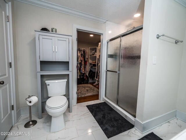 bathroom featuring a textured ceiling, toilet, an enclosed shower, and crown molding