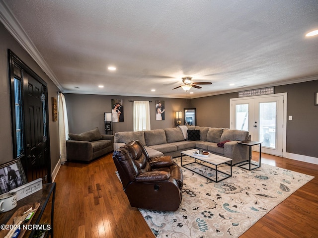 living room featuring ceiling fan, french doors, a textured ceiling, hardwood / wood-style flooring, and ornamental molding