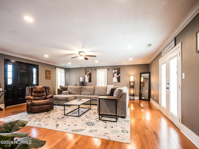 living room featuring french doors, light hardwood / wood-style flooring, ceiling fan, and ornamental molding