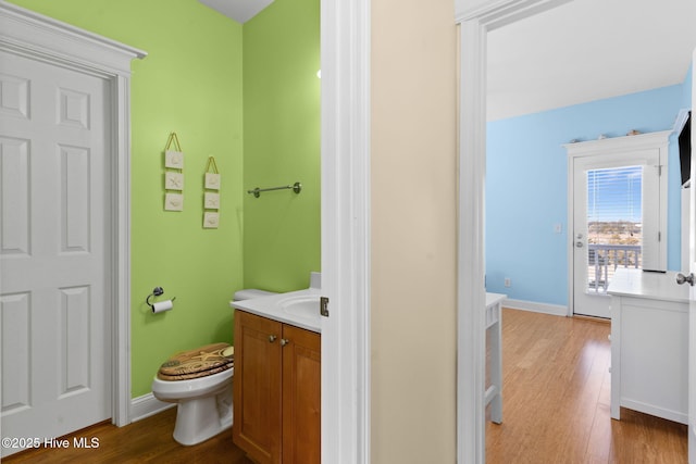 bathroom featuring vanity, baseboards, toilet, and wood finished floors