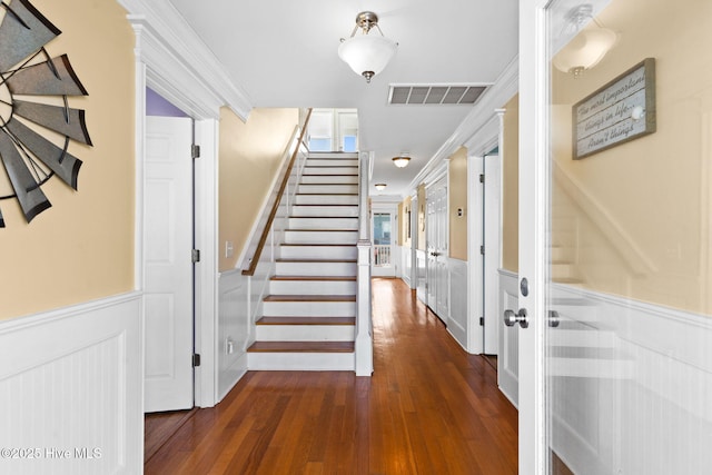 390 E Second St, Ocean Isle Beach, NC 28469 - staircase with a wainscoted wall, wood finished floors, a decorative wall, and crown molding