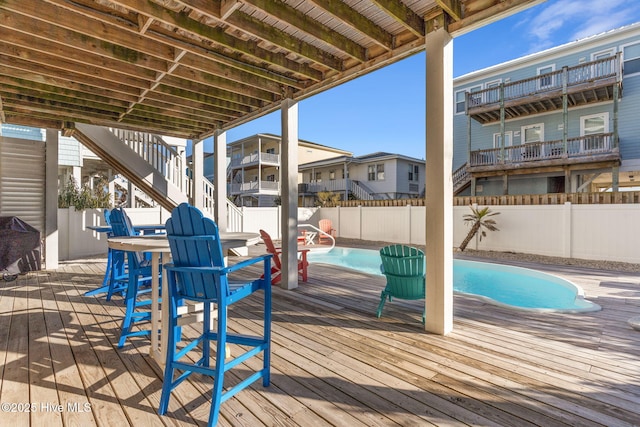 wooden deck featuring a fenced in pool, a fenced backyard, and stairway