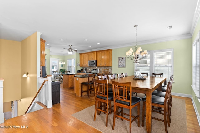 390 E Second St, Ocean Isle Beach, NC 28469 - dining area featuring light wood finished floors, ornamental molding, a chandelier, recessed lighting, and a ceiling fan