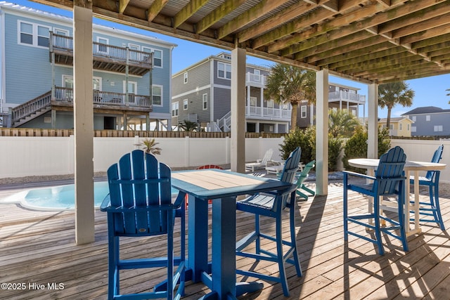 deck with fence, a residential view, outdoor dining area, and a fenced in pool