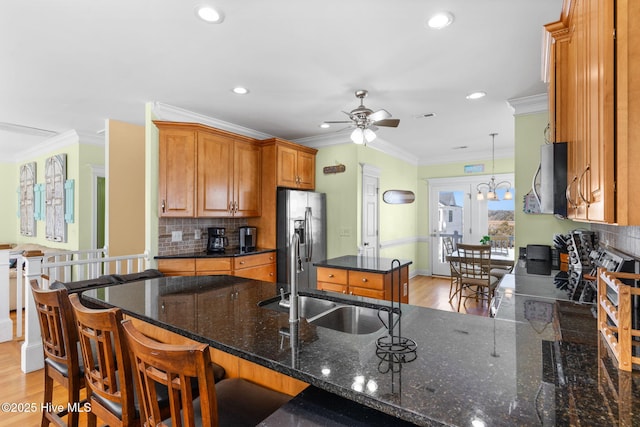 kitchen with crown molding, ceiling fan, appliances with stainless steel finishes, a sink, and backsplash