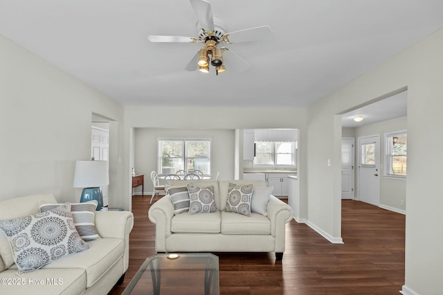 living room with sink, dark wood-type flooring, and ceiling fan