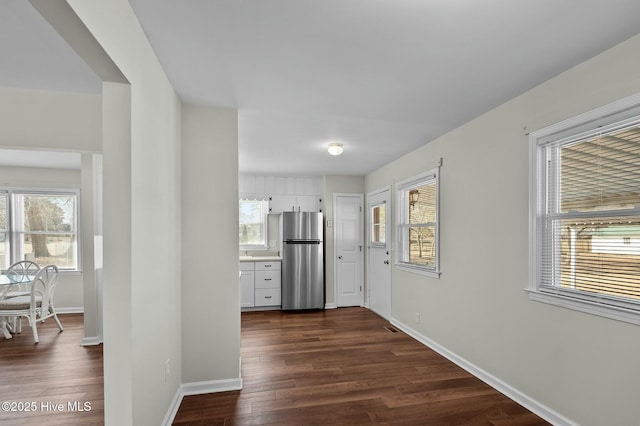 hall featuring a healthy amount of sunlight and dark hardwood / wood-style flooring