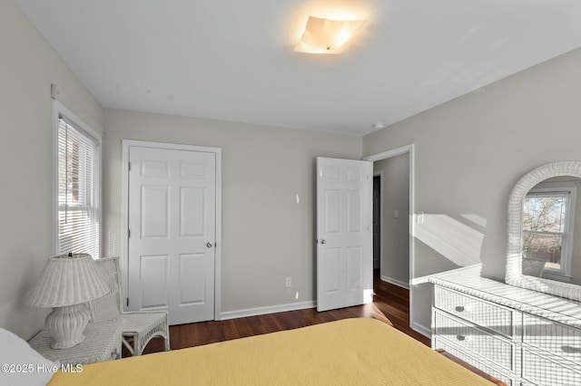 bedroom featuring multiple windows and dark wood-type flooring