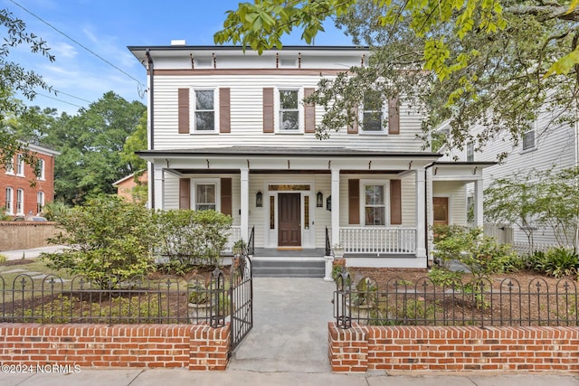 italianate house featuring a fenced front yard and covered porch