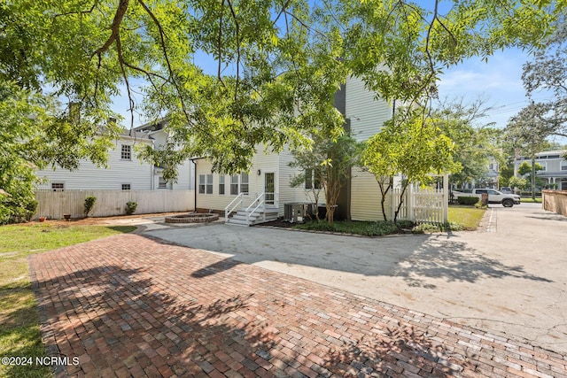 rear view of house with entry steps and fence