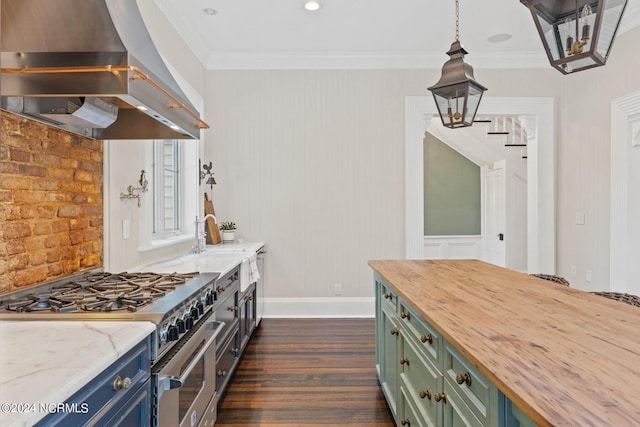 kitchen with green cabinets, butcher block counters, ornamental molding, stainless steel range, and wall chimney exhaust hood