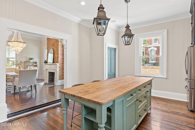 kitchen featuring pendant lighting, green cabinets, wooden counters, a center island, and an inviting chandelier