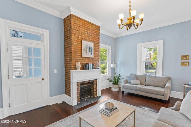 living room featuring ornamental molding, a chandelier, a brick fireplace, and dark hardwood / wood-style flooring