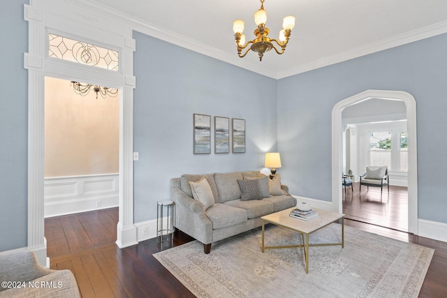 living room featuring dark wood-type flooring, a chandelier, and ornamental molding