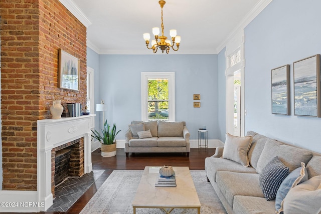 living area with a brick fireplace, dark wood-type flooring, baseboards, ornamental molding, and a notable chandelier