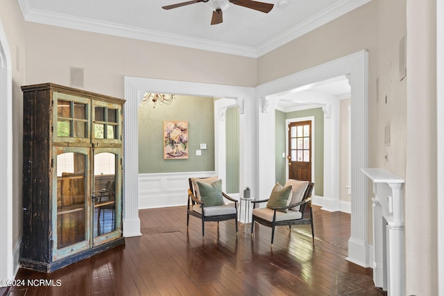 living area with dark hardwood / wood-style floors, ceiling fan, and ornamental molding