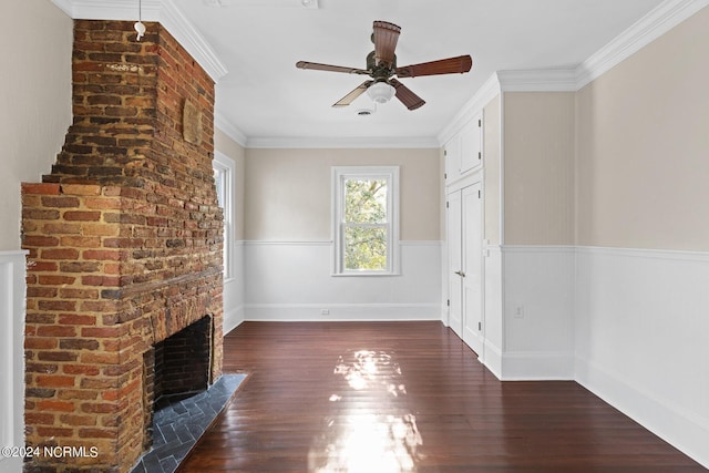 unfurnished living room featuring ceiling fan, a brick fireplace, crown molding, and dark hardwood / wood-style flooring