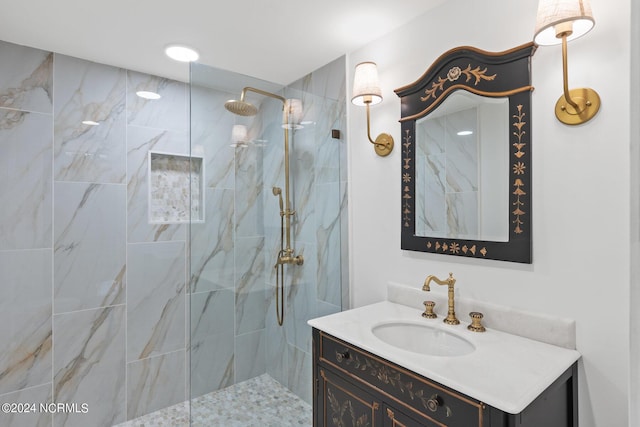 bathroom with vanity and a tile shower