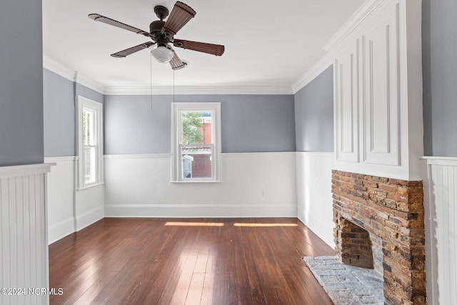 unfurnished living room with ceiling fan, dark wood-type flooring, ornamental molding, and a fireplace