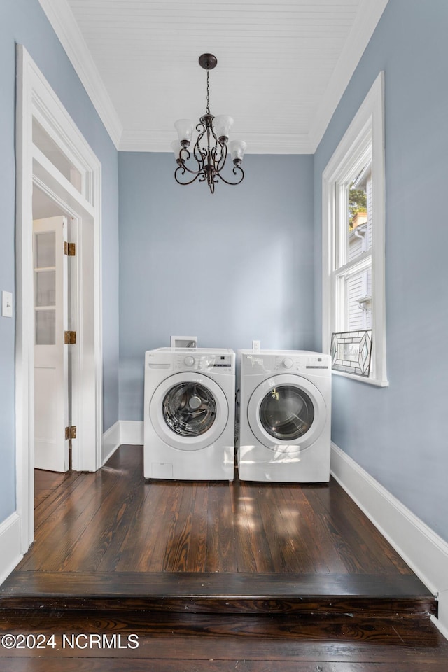 laundry room featuring a notable chandelier, washing machine and clothes dryer, crown molding, and hardwood / wood-style flooring