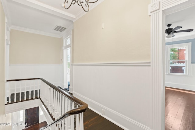 staircase with visible vents, wainscoting, hardwood / wood-style flooring, and ornamental molding