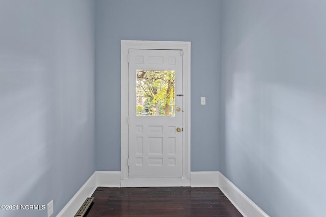 doorway with dark wood-type flooring and baseboards