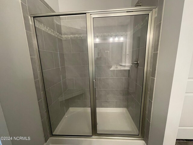 bathroom with a shower with door