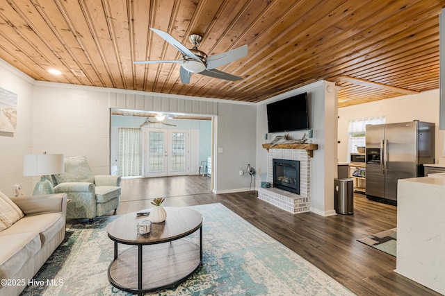 living room featuring dark hardwood / wood-style flooring, a fireplace, ornamental molding, and wood ceiling