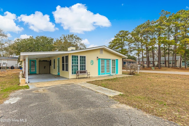 view of front facade with a front lawn and a carport