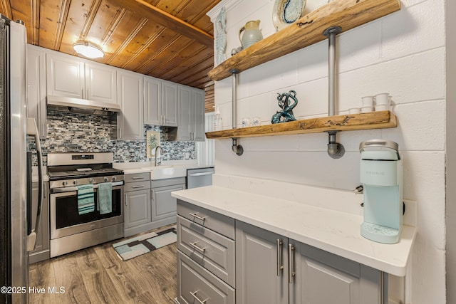 kitchen featuring wood ceiling, gray cabinets, wood-type flooring, appliances with stainless steel finishes, and light stone countertops