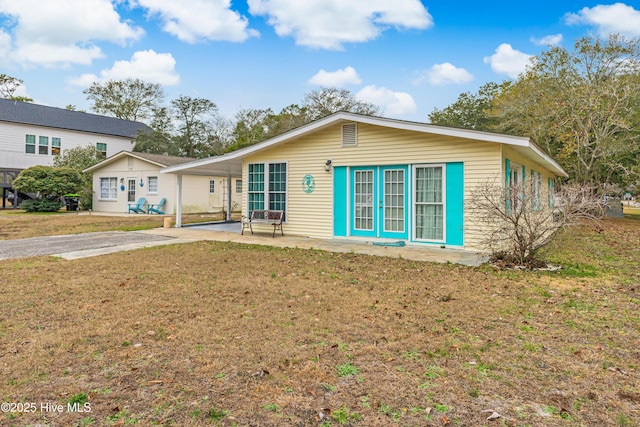 single story home with a patio area, a front lawn, and a carport