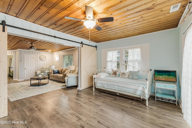 bedroom featuring ceiling fan, wood ceiling, hardwood / wood-style floors, and a barn door