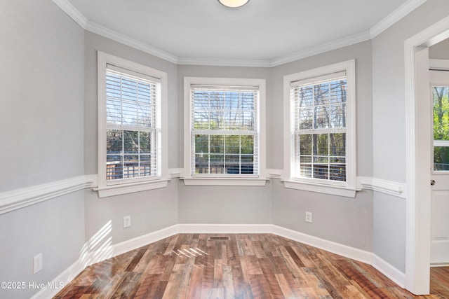 interior space featuring hardwood / wood-style floors, ornamental molding, and a healthy amount of sunlight