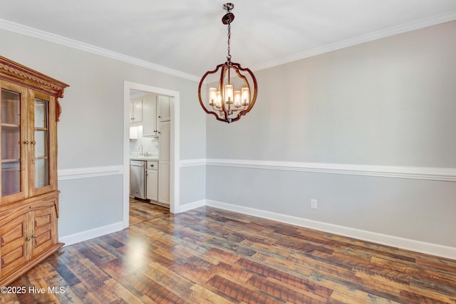 empty room featuring a notable chandelier, dark hardwood / wood-style floors, ornamental molding, and sink