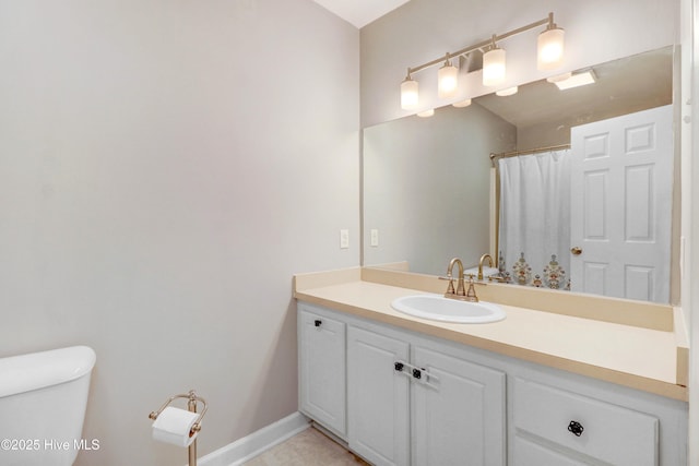 bathroom with tile patterned flooring, vanity, and toilet