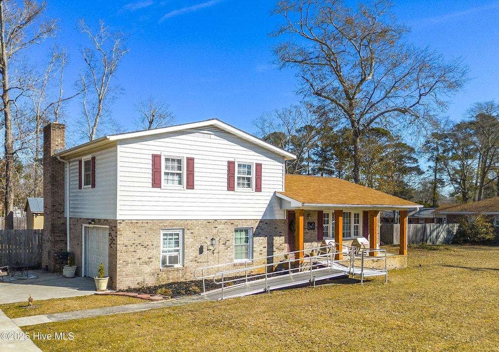 tri-level home featuring a porch, a front lawn, and a garage