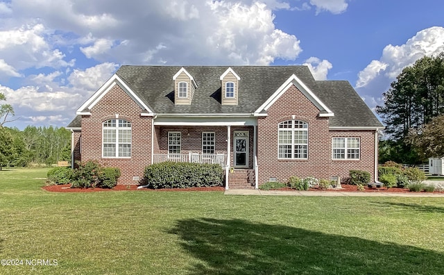 view of front of house with covered porch, brick siding, and a front lawn