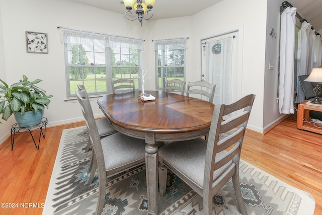 dining space with a notable chandelier, baseboards, and wood finished floors