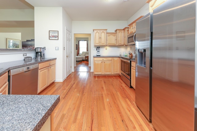 kitchen featuring appliances with stainless steel finishes, light brown cabinets, and light wood-style floors