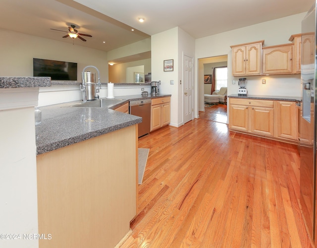 kitchen featuring light brown cabinets, light wood-style flooring, a sink, open floor plan, and stainless steel dishwasher