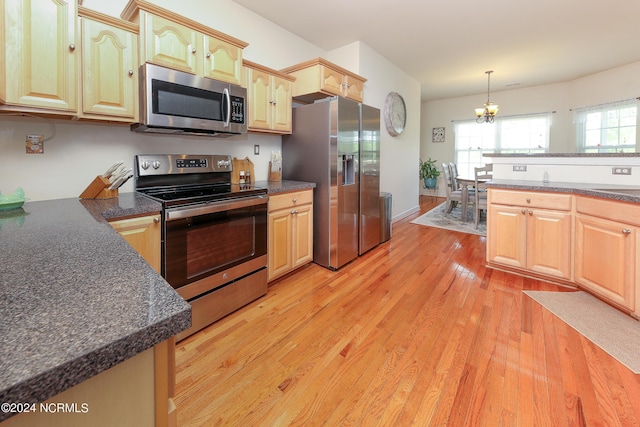 kitchen featuring kitchen peninsula, light brown cabinetry, stainless steel appliances, sink, and light hardwood / wood-style flooring